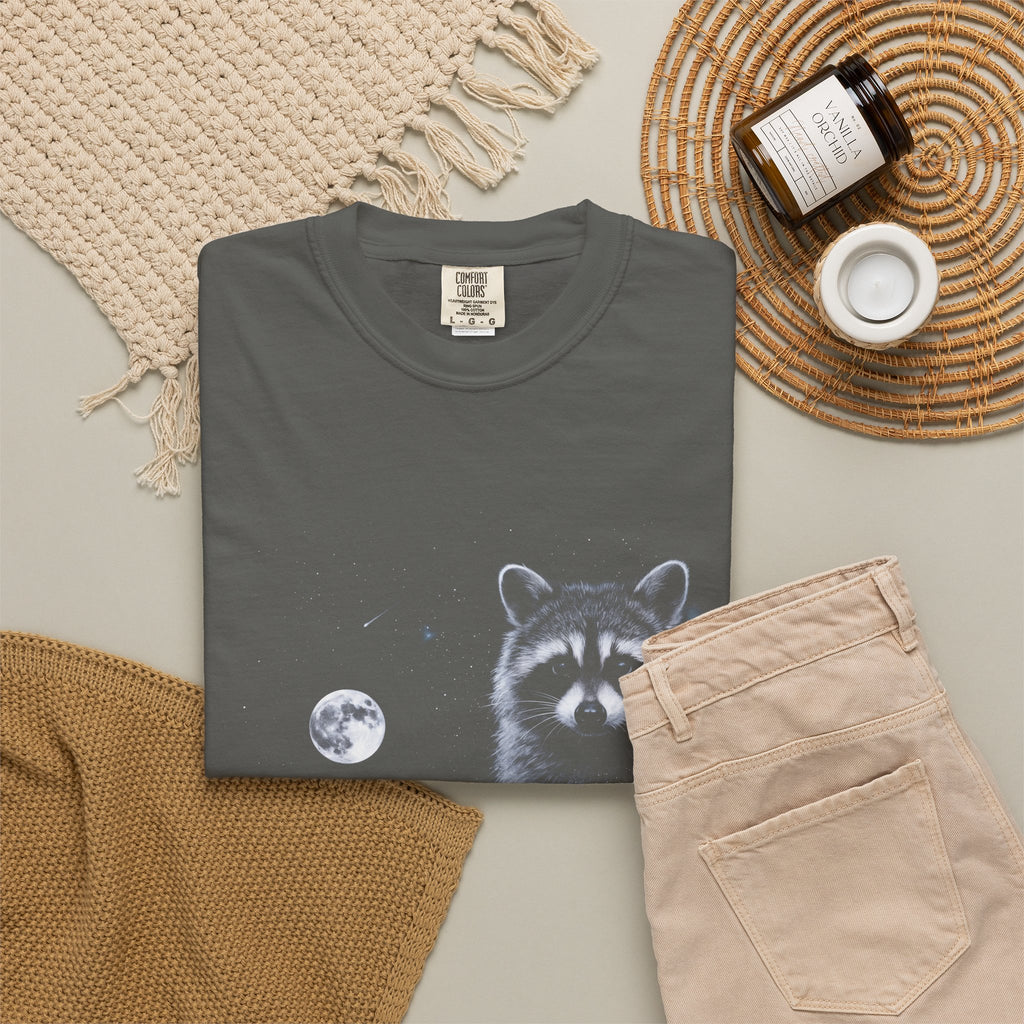 Cold-toned airbrushed raccoon howling at the moon on black, in classic 90s nature-tee style.