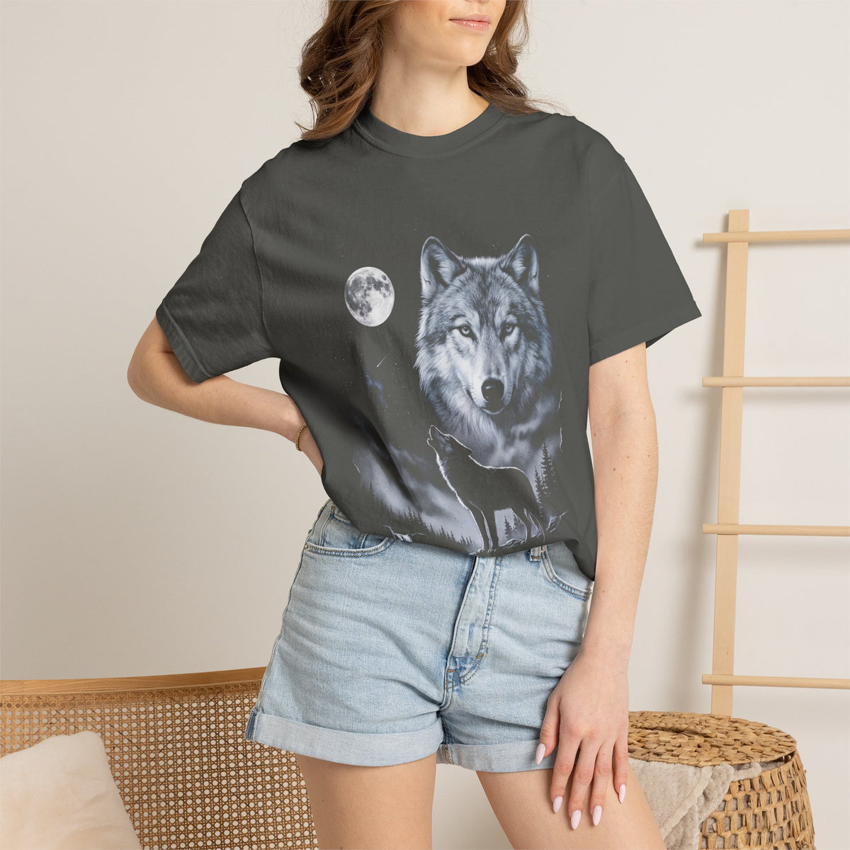 Airbrushed wolf howling at a full moon in cold silver, ash-grey and ice-blue tones on black, 90s nature-tee style.