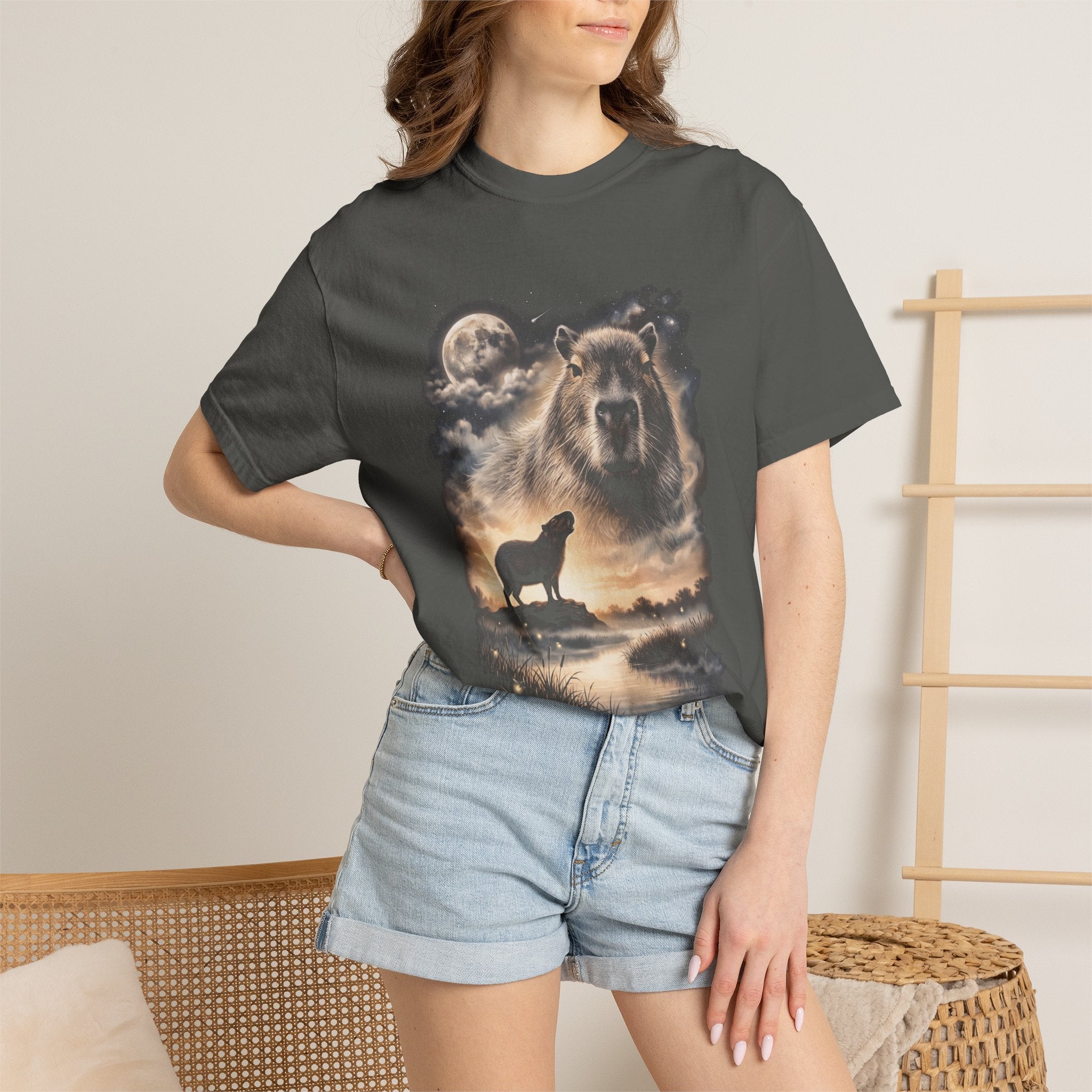 Photorealistic double-exposure design of a capybara howling at a full moon over misty hills, in cream and gold on a dark tee.