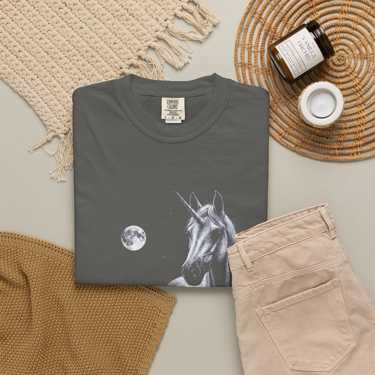 Airbrushed illustration of a unicorn howling at a full moon in white, silver, and ice-blue tones on black.